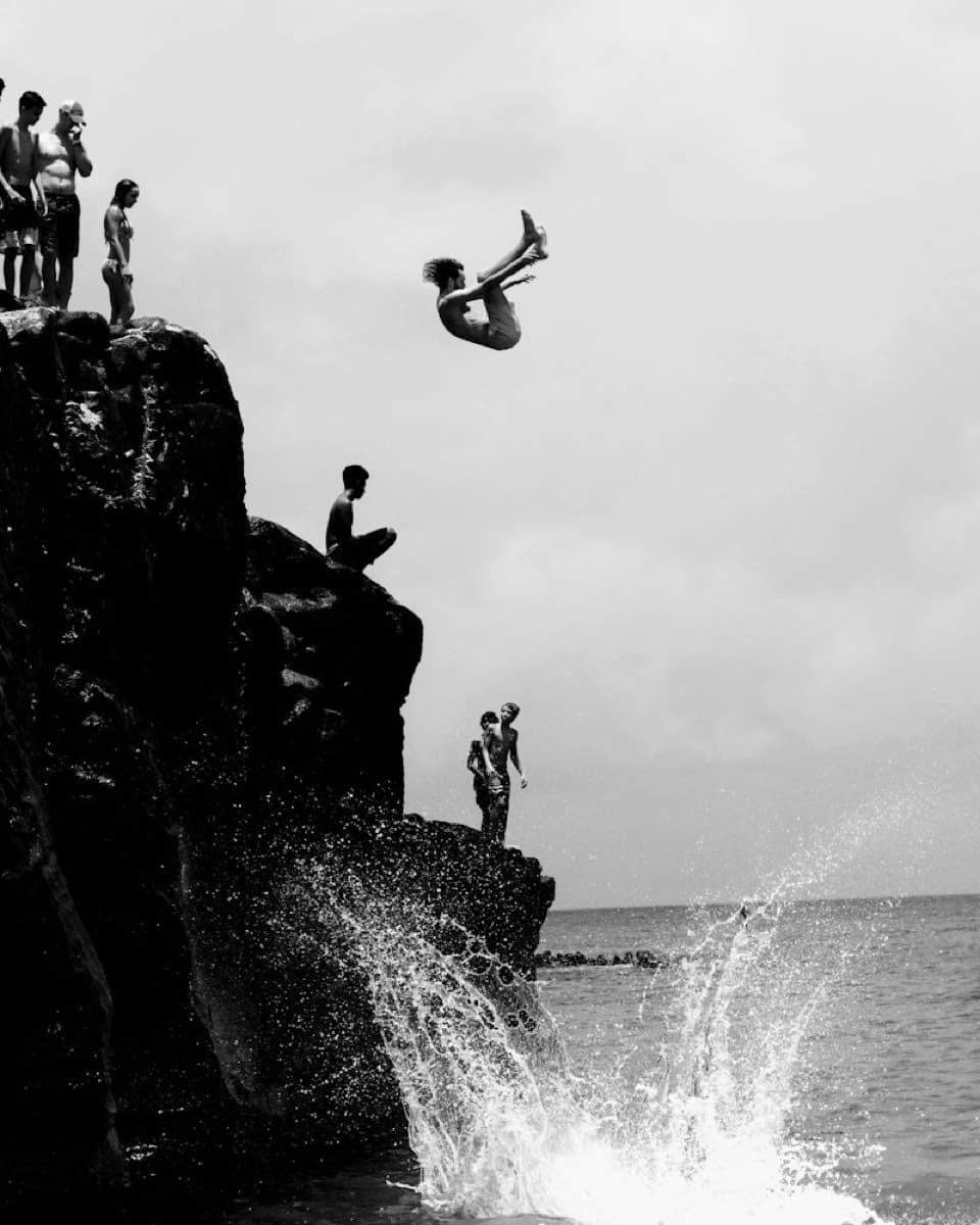 Sample photo: a person jumping off a cliff into the sea